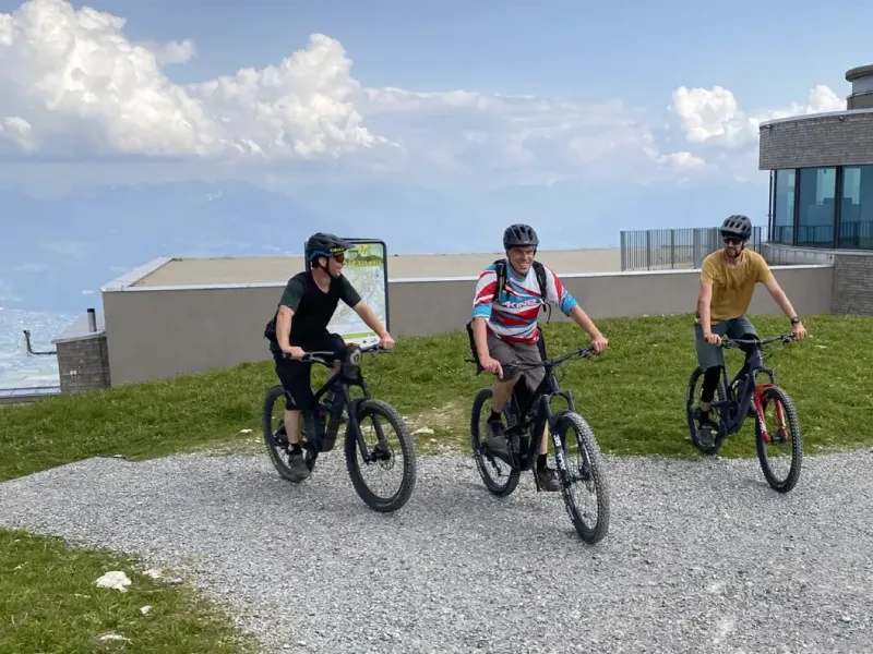 Drei Mountainbiker unterwegs auf einem Kiesweg in den Bergen.